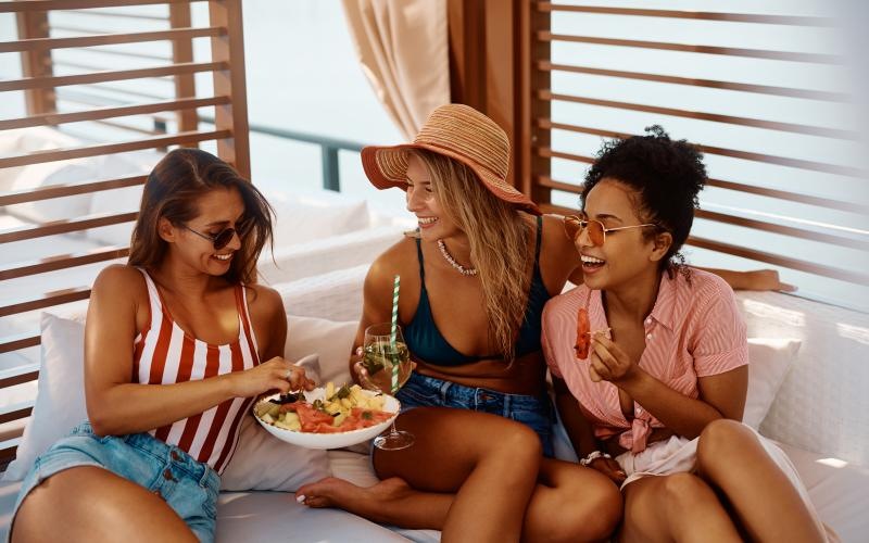 a group of women sitting on a couch eating food