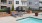 a pool and chairs by a building