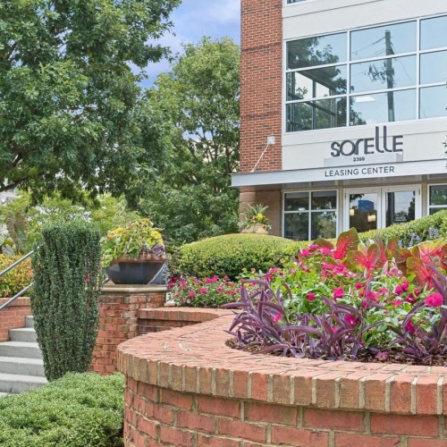 The essence of exceptional living a brick wall with a brick walkway and plants and a building