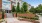 a brick walkway with plants and trees