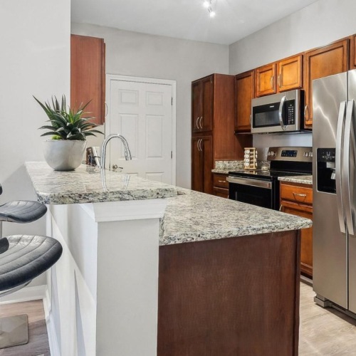 Spacious kitchens with thoughtful details a kitchen with a fridge and a chair